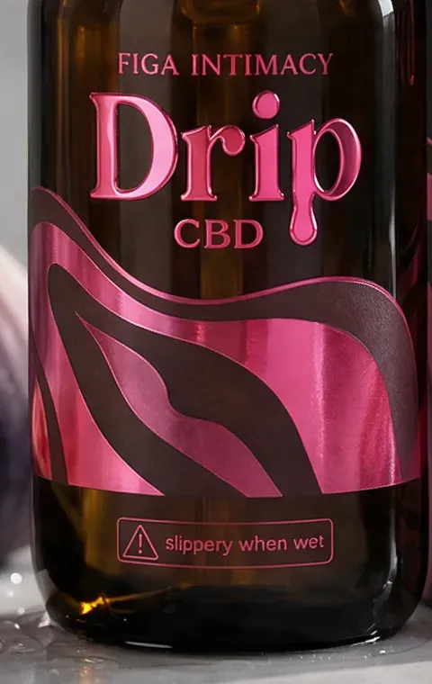 Close-up of the Drip label: foil pink wordmark and a ‘slippery when wet’ warning